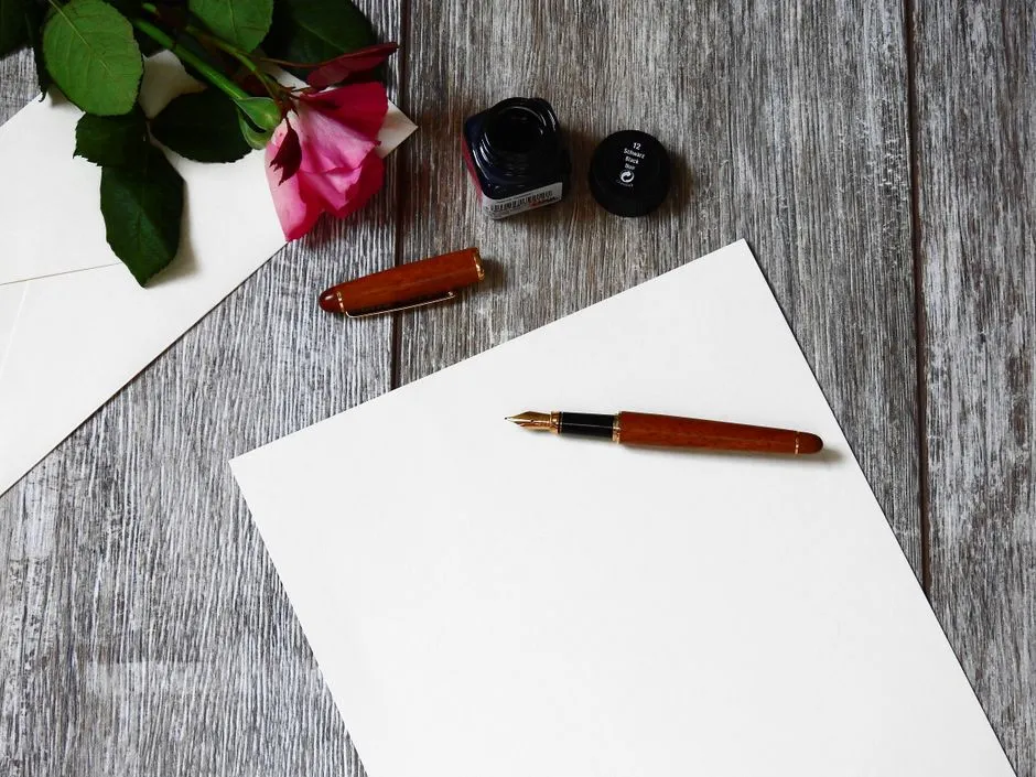 A fountain pen resting on white paper, evoking careful written correspondence